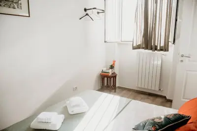 a white room with a bed with two towels on it at Vatican Suite 