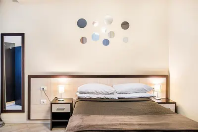 a bedroom with a large bed and a mirror at Interno5 in Rome