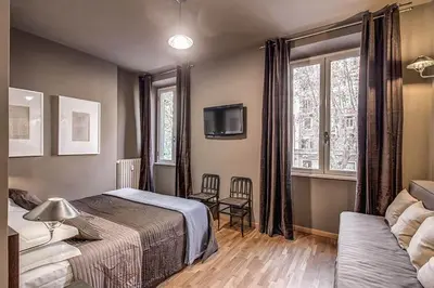 a bedroom with a bed and a couch and a tv at Interno5 in Rome
