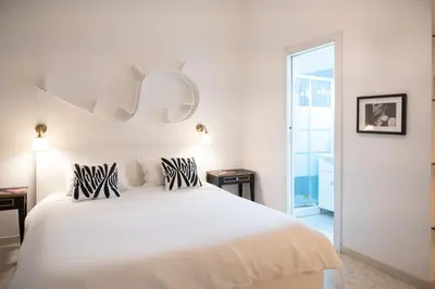 a white bedroom with a white bed with zebra pillows at Vita Nova House 3 camere 3 bagni perfetta per famiglie e gruppi a due passi da Termini in Rome