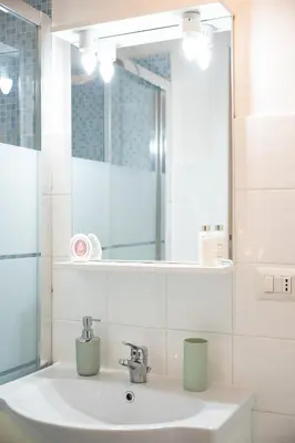 a bathroom with a sink with a mirror and a sink at Vita Nova House 3 camere 3 bagni perfetta per famiglie e gruppi a due passi da Termini in Rome