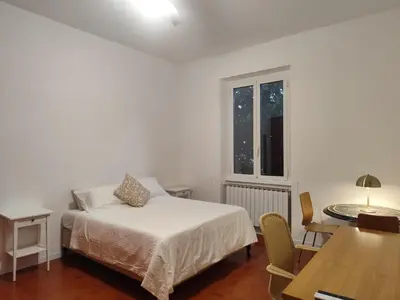a bedroom with a bed and a table and a window at Saint Peters Place 2BR near Vatican in Rome
