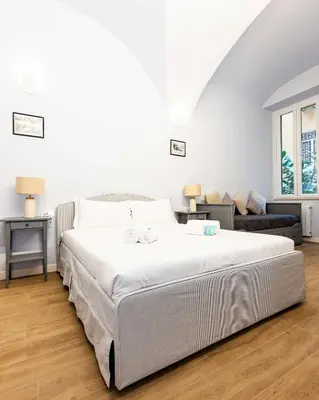 a white bedroom with a large bed and a couch at Monti Nonna Francesca - ZENO 49 in Rome