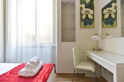 a bedroom with a red bed and a desk and a mirror at Lata Luxury Apartment in Rome