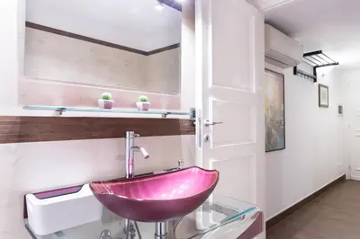 a bathroom with a pink sink in a room at Casa Enriqueta in Rome