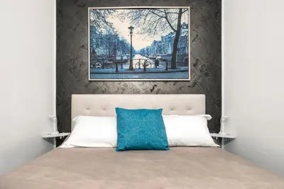 a bedroom with a large bed with a blue pillow at Casa Enriqueta in Rome