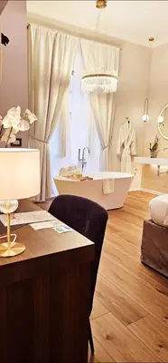 a bathroom with a tub and a sink and a table at STOA ROME Boutique Suites in Rome