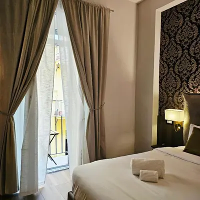 a bedroom with a bed and a large window at STOA ROME Boutique Suites in Rome