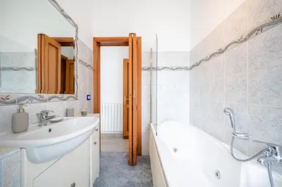 a bathroom with a sink and a tub and a bath tub at Via Niso Apartment in Rome