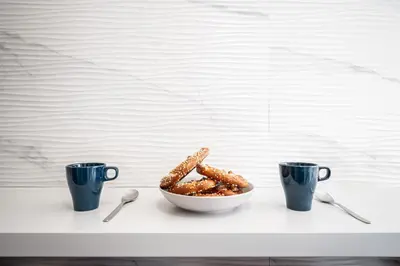 a bowl of pretzels on a table with two cups at Via Niso Apartment in Rome