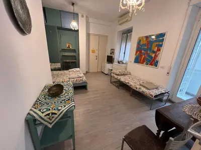 a room with three beds and a table and chairs at Cozy Studio near Vaticano in Rome
