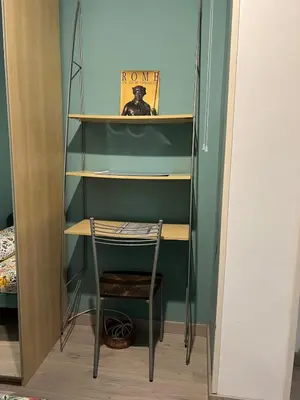 a chair in a closet with a book shelf at Cozy Studio near Vaticano in Rome