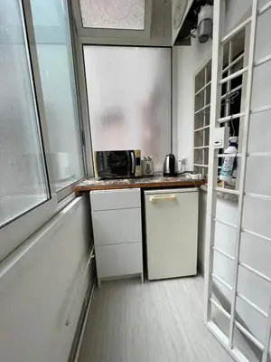 a small kitchen with white cabinets and a microwave at Cozy Studio near Vaticano in Rome