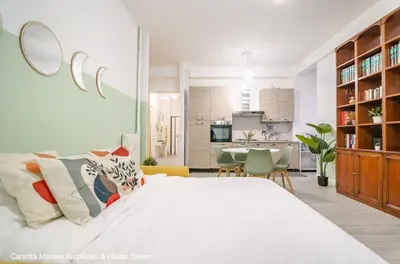 a white bedroom with a large bed and a dining room at Acquedotti House in Rome