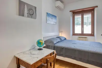 a small bedroom with a bed and a table at Dimora Savorelli, ampio appartamento zona Vaticano in Rome