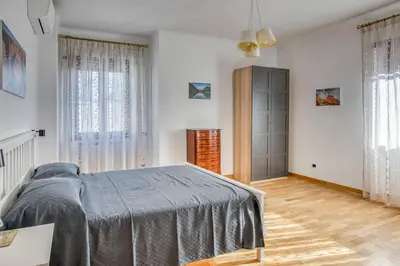 a bedroom with a bed and some windows at Dimora Savorelli, ampio appartamento zona Vaticano in Rome