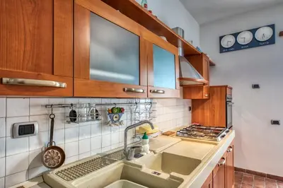 a kitchen with wooden cabinets and a sink at Dimora Savorelli, ampio appartamento zona Vaticano in Rome