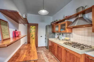 a kitchen with wooden cabinets and a stove top oven at Dimora Savorelli, ampio appartamento zona Vaticano in Rome