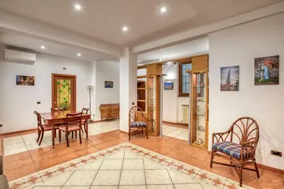 a living room with a table and chairs at Dimora Savorelli, ampio appartamento zona Vaticano in Rome