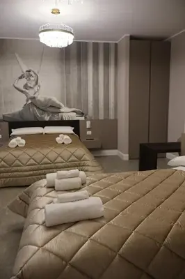 a bedroom with a large bed with towels on it at COLOSS IMPERIAL SUITE Guest House in Rome