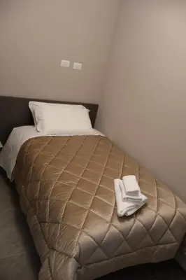 a bed with two white towels on top of it at COLOSS IMPERIAL SUITE Guest House in Rome