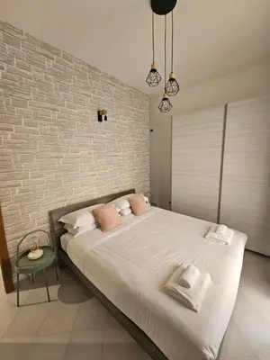 a bedroom with a large bed and a brick wall at Domus Imperiali in Rome