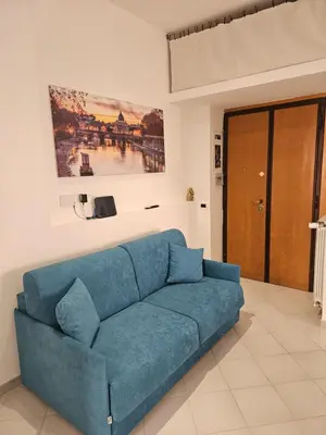 a blue couch in a living room with a painting on the wall at Domus Imperiali in Rome