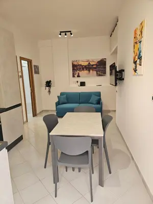 a living room with a table and a blue couch at Domus Imperiali in Rome
