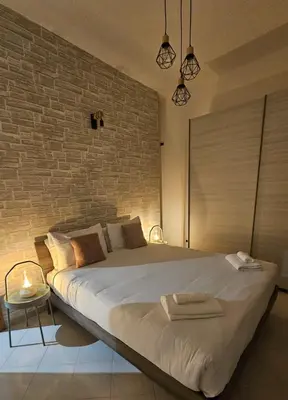 a bedroom with a large bed with a brick wall at Domus Imperiali in Rome