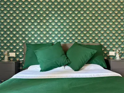 a green bed with two green pillows and a wall at Luxury Jacuzzi Suites Rome - You Rhome in Rome