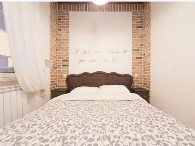 a bedroom with a bed and a brick wall at Suite Old Testaccio 2 in Rome