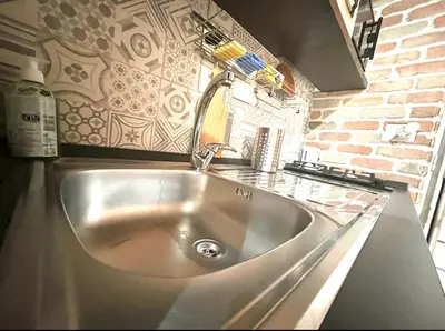 a stainless steel sink in a kitchen with a brick wall at Suite Old Testaccio 2 in Rome