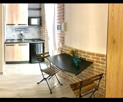 a kitchen with a black table and two chairs and a counter at Suite Old Testaccio 2 in Rome
