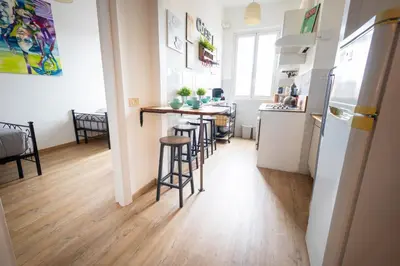a kitchen and living room with a counter and stools at Urban Trastevere Rome apartment Ripa 11 in Rome