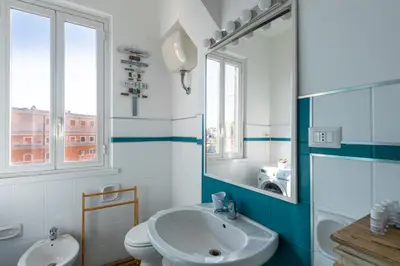 a bathroom with a sink and a toilet and a mirror at Urban Trastevere Rome apartment Ripa 11 in Rome
