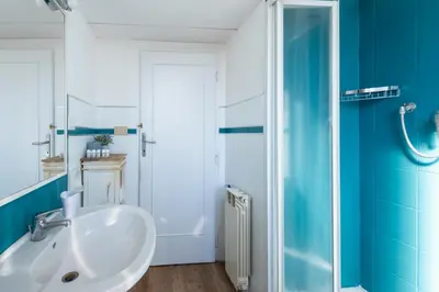 a bathroom with a white sink and a blue wall at Urban Trastevere Rome apartment Ripa 11 in Rome