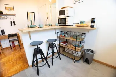 a kitchen with two stools and a counter with a microwave at Boutique Trastevere Rome apartment Ripa 12 in Rome