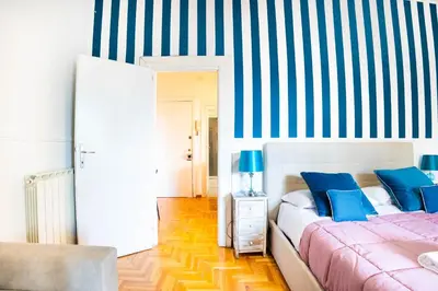 a bedroom with two beds and a striped wall at Boutique Trastevere Rome apartment Ripa 12 in Rome
