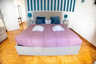 a large pink bed in a room with wooden floors at Boutique Trastevere Rome apartment Ripa 12 in Rome