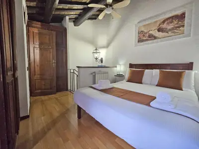 a bedroom with a large white bed with a ceiling at Pantheon Penthouse in Rome