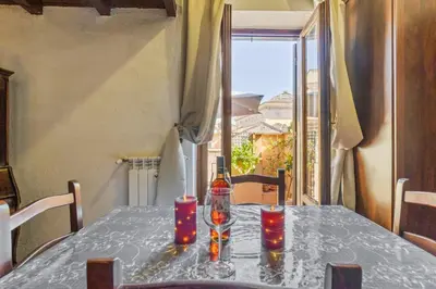 a table with a bottle of wine and candles on it at Pantheon Penthouse in Rome