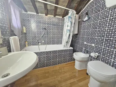 a bathroom with a toilet and a tub and a sink at Pantheon Penthouse in Rome