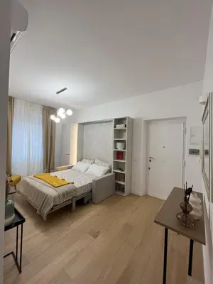 a white bedroom with a bed and a table at Saint Paul Gateway in Rome