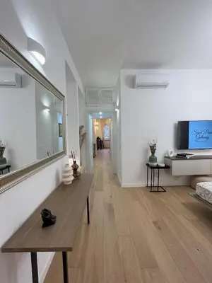 a living room with a wooden table and a television at Saint Paul Gateway in Rome