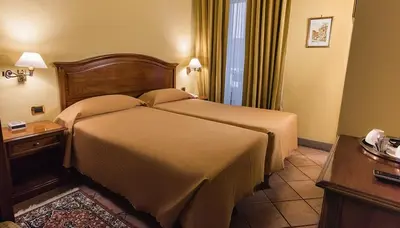 a hotel room with a large bed and a desk at Hotel Bramante in Rome