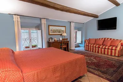 a bedroom with an orange bed and a couch at Hotel Bramante in Rome