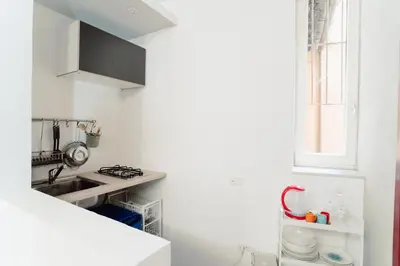 a white kitchen with a sink and a window at Monti Urban Loft by Valentina's Dream in Rome
