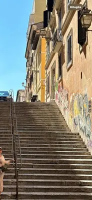 a man standing on the stairs of a building with graffiti at Monti Urban Loft by Valentina's Dream in Rome