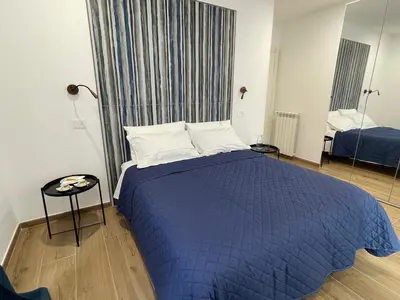 a bedroom with a bed with a blue comforter at SAINT PETER home and holiday apartment in Rome
