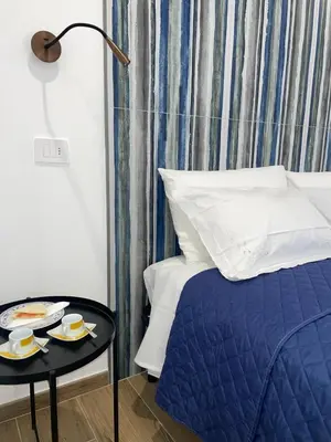a bed with a blue comforter and a table with a plate of food at SAINT PETER home and holiday apartment in Rome